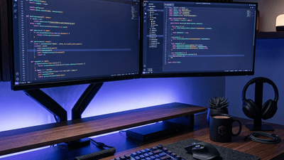 Modern developer workspace with dual monitors and code on screen